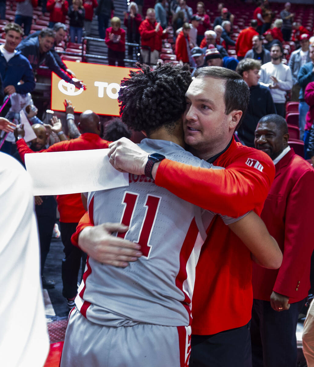 UNLV head coach Kevin Kruger hugs game winning scorer guard Dedan Thomas Jr. (11) on the court ...