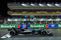 Mercedes driver George Russell crosses the finish line as the flag waves in the tower winning t ...