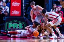 UNLV guard Dedan Thomas Jr. (11) battles for a loose ball against Wyoming Cowboys forward Matij ...