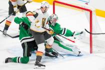 Dallas Stars goaltender Jake Oettinger, back right, gloves a shot by Vegas Golden Knights left ...