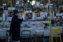 A woman looks at a display of empty chairs representing hostages held by the Hamas militant gro ...