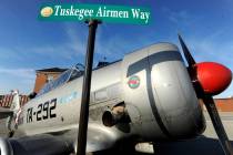 FILE - The Tuskegee Airmen Way street sign is briefly displayed in front of a 1943 North Americ ...