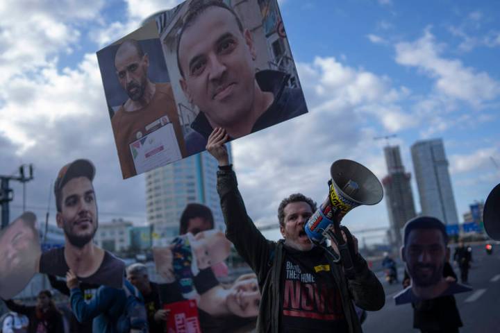 A demonstrator holding photos of freed Israeli hostage Eli Sharabi before and after his captivi ...