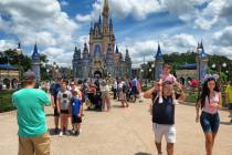 Families gather for a selfie in front of Cinderella Castle at the Magic Kingdom at Walt Disney ...