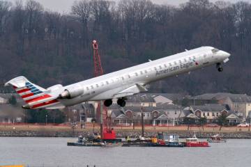 Salvage crews work on recovering wreckage near the site in the Potomac River of a mid-air colli ...