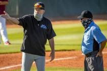 Basic High School head coach Scott Baker argues an out with the umpire versus Desert Oasis ...