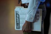 FILE - A person waits in a line for a prospective employer at a job fair, Thursday, Aug. 29, 20 ...