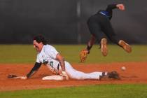 Basic second baseman Lyndon Lee (15) leaps over Palo Verde infielder Luke Herrera (12) as he sl ...