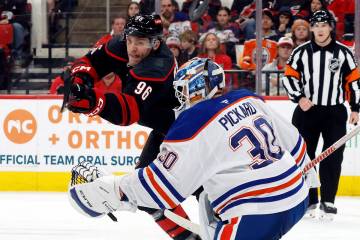 Carolina Hurricanes' Mikko Rantanen (96) tries to deflect the puck past Edmonton Oilers goalten ...