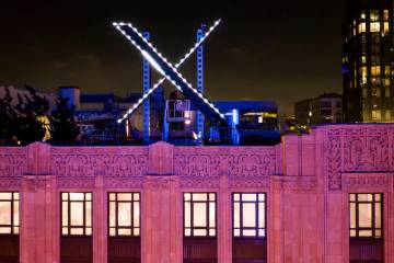 FILE - Workers install lighting on an "X" sign atop the company headquarters, formerl ...