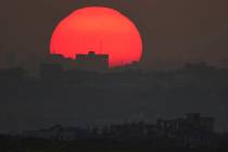 The sun sets behind the buildings that were destroyed during the Israeli air and ground offensi ...